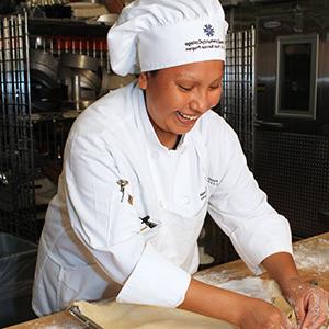 皮马社区学院烹饪最全菠菜导航的学生穿着厨师夹克在厨房工作